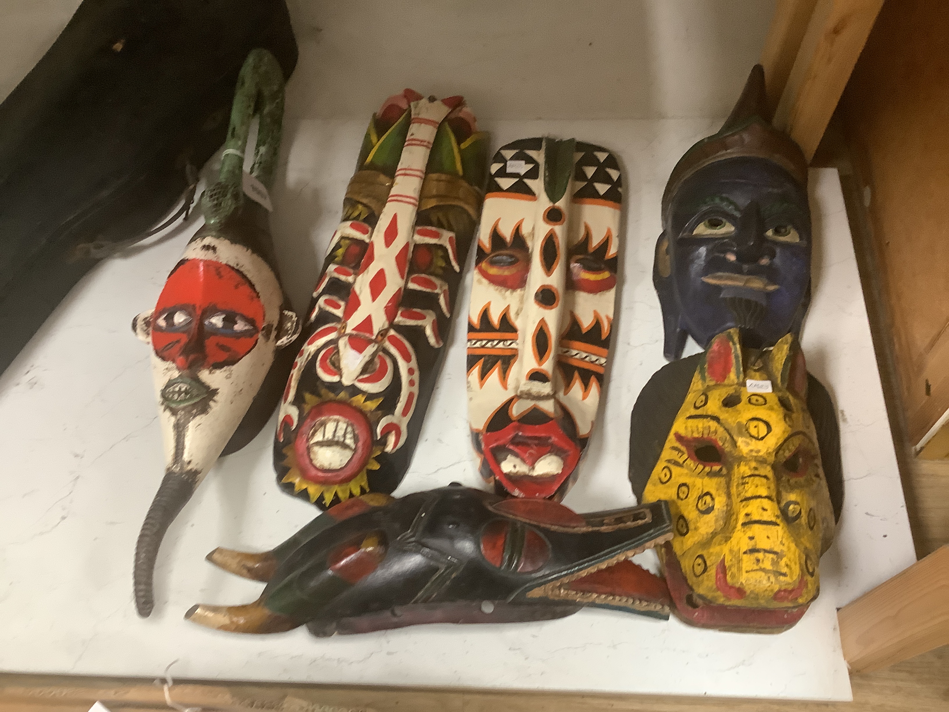 Six Indonesian tribal painted wood masks, largest 60cm high